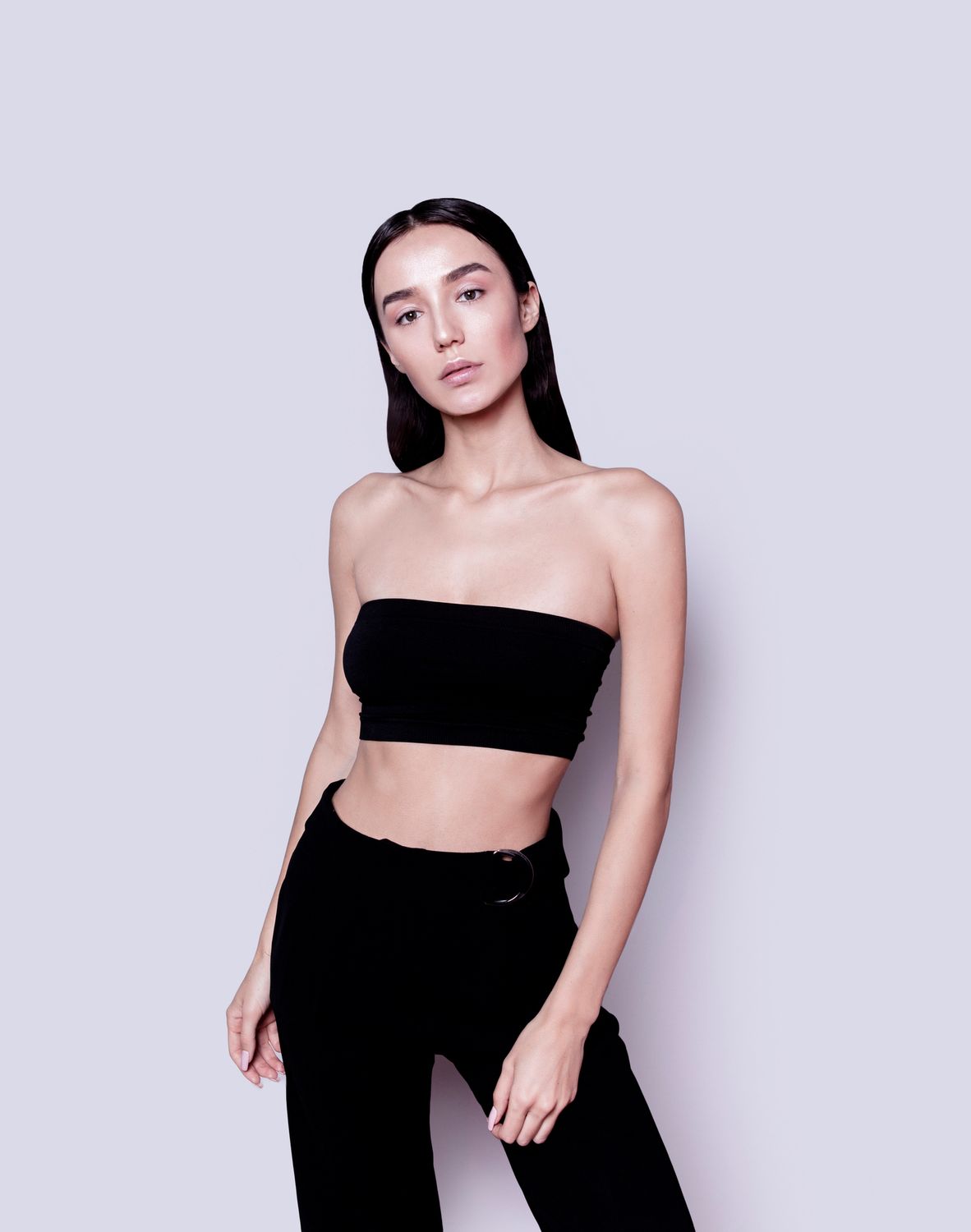 Model in black clothing against a pale background.